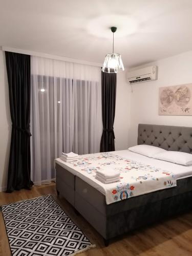 una camera con un grande letto e un lampadario a braccio di Apartmani Pasara a Baošići