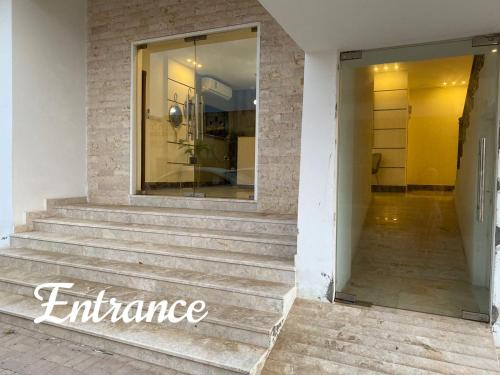 a store entrance with stairs and a window at Lovely Beach Apartment in Salalah