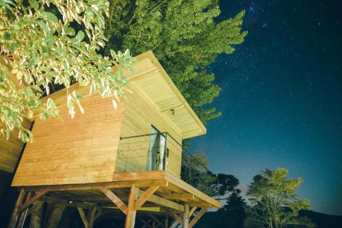 a tree house on a wooden stand in the woods at All Black Resort in Monte Verde