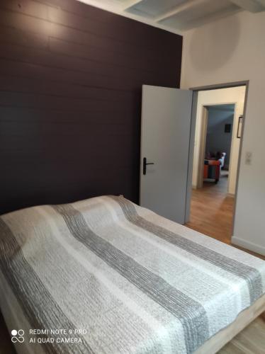 a bedroom with a large bed with a black wall at Basilic, 4 pers. Villa Saint Antoine, Orcival, Sancy Auvergne in Orcival