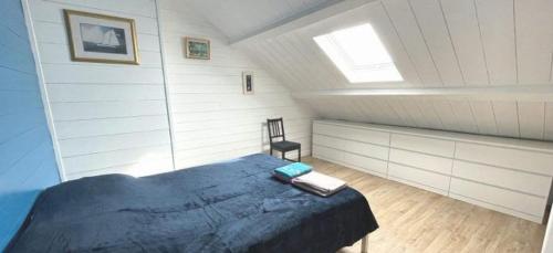 a attic bedroom with a bed and a window at Basilic, 4 pers. Villa Saint Antoine, Orcival, Sancy Auvergne in Orcival