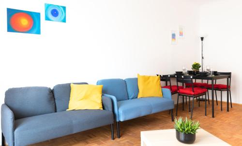 a living room with a blue couch and a table at Pal's Favoriten Apartment in Vienna