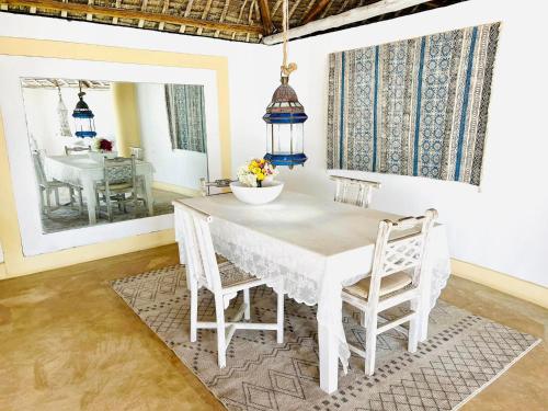 a white dining room with a white table and chairs at Dream Luxury B&b Watamu in Watamu