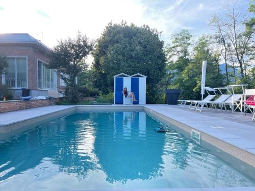 a bride standing in front of a swimming pool at Villa Silvia Olivetti in Banchette