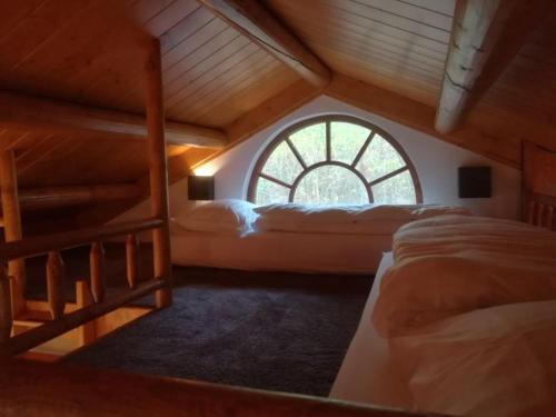 a attic room with two beds and a window at Lutterlodge in De Lutte