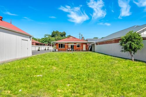 a house with a green yard in front of a house at Swainson on Coombe in Woodville