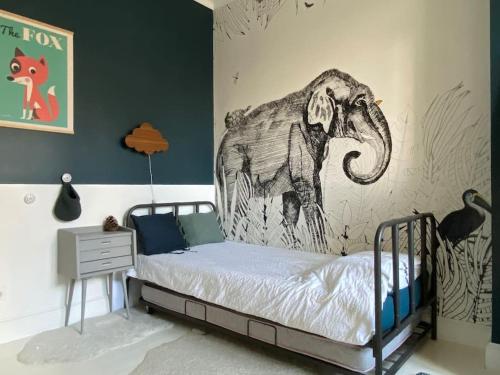 1 dormitorio con 1 cama con un mural de elefantes en la pared en Family house Bordeaux centre, pool + garden, en Burdeos
