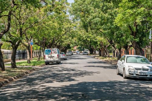 a street with cars parked on the side of a tree lined road at Swainson on Coombe in Woodville
