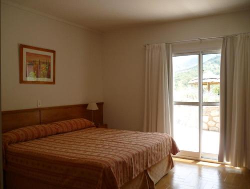 a bedroom with a bed and a large window at Rincon del Valle in Merlo