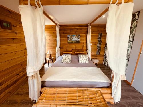 Schlafzimmer mit einem Bett mit Moskitonetzen in der Unterkunft Gîte Paradis Lé La in L’Étang-Salé