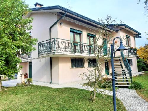uma casa com uma varanda e uma escadaria em GIOIA NELLE SELVE Family House - Casa Vacanze em Mogliano Veneto