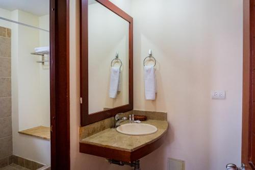 a bathroom with a sink and a mirror at Hotel Peñon Suites in Girardot
