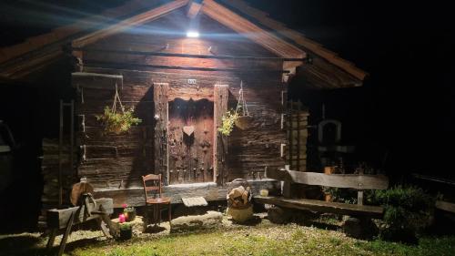 an old cabin with a wooden door at night at Miramont Horse Trekking Hostel in Saicourt