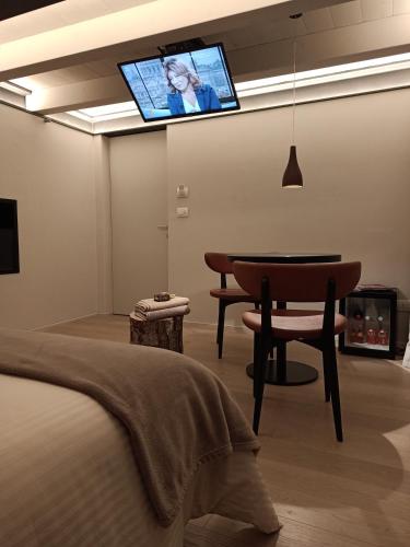 1 dormitorio con mesa y TV en la pared en V&V RentRoom Design, en Gignod