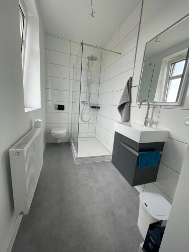 a white bathroom with a sink and a shower at MR Ferienwohnung - Wohnung Greta in Schellerten