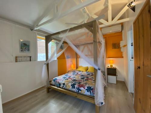 ein Schlafzimmer mit einem Himmelbett in der Unterkunft Charmant bungalow avec piscine Kaz' Basse in Bouillante