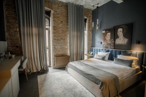 una camera da letto con un letto e un muro di mattoni di Victoria Deluxe Hotel a Černivci