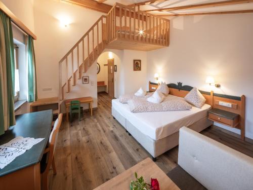 a large room with a bed and a staircase at Hotel B&B Martha in Brunico