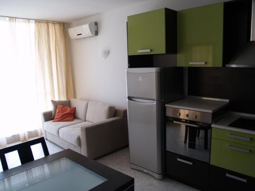 a kitchen with a stove and a couch in a room at Apartment N4 in Sunset Beach 2,Слънчев бряг in Sunny Beach