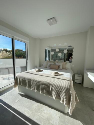 ein weißes Schlafzimmer mit einem großen Bett und einem großen Spiegel in der Unterkunft Marbella Centre with terrace and pool in Marbella