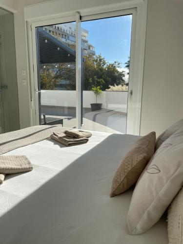 ein weißes Bett mit Kissen und ein großes Fenster in der Unterkunft Marbella Centre with terrace and pool in Marbella