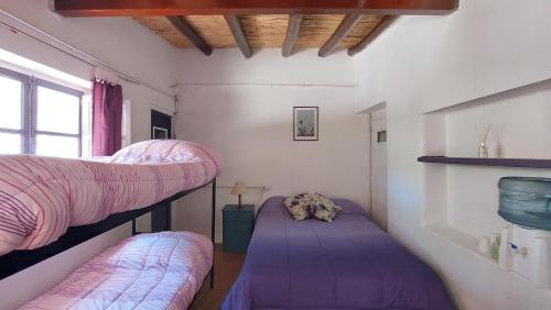 two bunk beds in a room with purple sheets at Hospedaje Don Alberto in Potrerillos