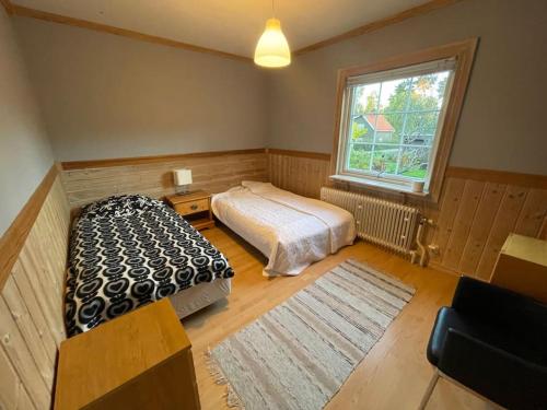 Large cozy villa between Stockholm and Oslo في Åmotsfors: غرفة نوم بسرير ونافذة