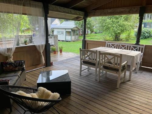 Large cozy villa between Stockholm and Oslo في Åmotsfors: فناء على طاولة وكراسي على السطح