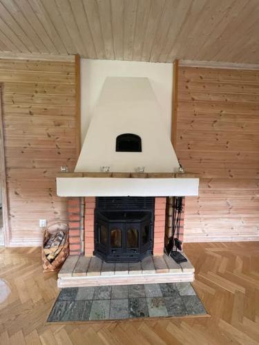 a fireplace in a room with a stove at Large cozy villa between Stockholm and Oslo in Åmotsfors