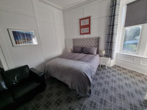 a bedroom with a bed and a chair in it at Windsor house in Stranraer