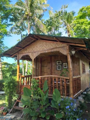 a small bamboo house with a porch at Casa de Corazon in Kandabong