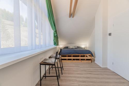 a bedroom with a bed and a table and chairs at Chata Zdiarka 4M in Ždiar
