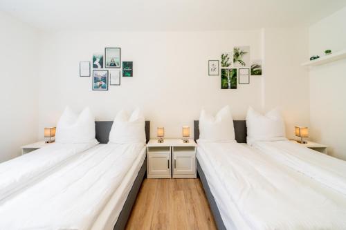 2 łóżka w pokoju z białymi ścianami w obiekcie Classic Apartments - zentral - bis 6 Personen - Parkplatz w mieście Coburg