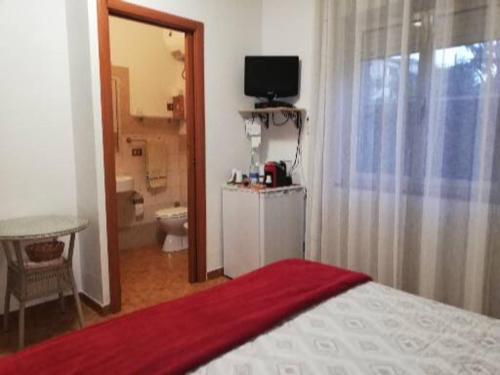 a bedroom with a bed and a bathroom with a toilet at A Domo Mia in Castelsardo