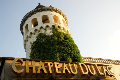 a clock tower with a sign in front of a chateau dip at Martin's Château Du Lac in Genval