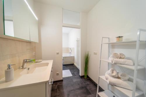 a bathroom with a sink and a mirror and towels at Classic Apartments - zentral - bis 6 Personen - Parkplatz in Coburg