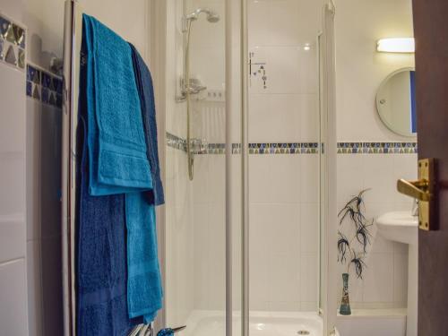a bathroom with a shower with blue towels on it at Roseville Annex in Markinch