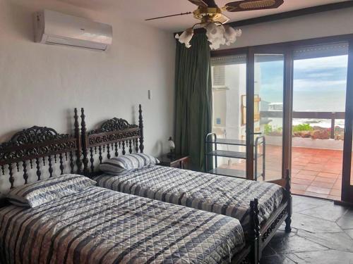 two beds in a bedroom with a balcony at Departamento Mar Punta del Este in Punta del Este