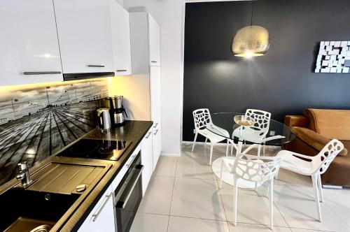 a kitchen with white cabinets and a table and chairs at Sopocka Bryza in Sopot