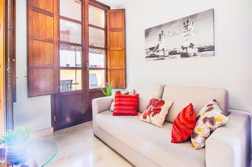 un soggiorno con divano bianco e cuscini colorati di CARTAGENAFLATS, Apartamentos Calle Mayor, CITY CENTER a Cartagena