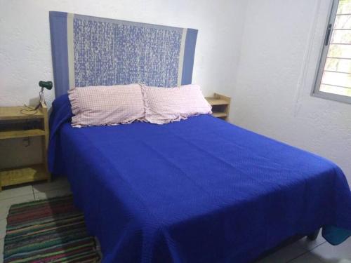a bedroom with a blue bed with a blue blanket at Casa en La Esmeralda Uruguay in La Esmeralda 