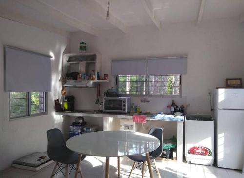 een keuken met een tafel en stoelen en een koelkast bij Casa en La Esmeralda Uruguay in La Esmeralda