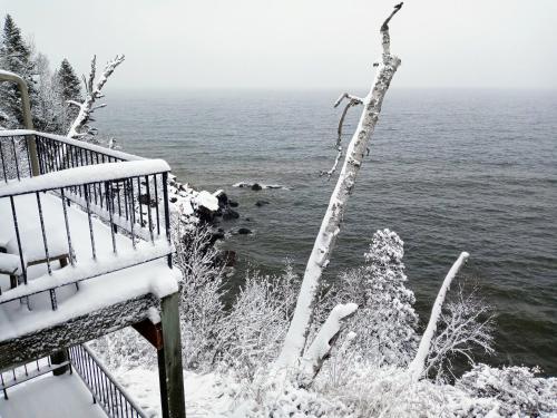a snowy view of the ocean from a balcony at Cliff Dweller on Lake Superior in Tofte