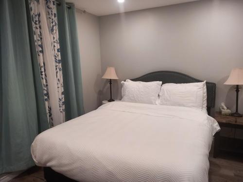 a bedroom with a bed with white sheets and pillows at Splendid Place in Kingston