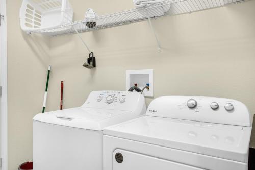 a white laundry room with a washer and dryer at Fun Family Villa Pool BBQ Near Disney World 5BR in Kissimmee