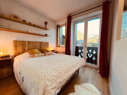 - une chambre avec un lit et une grande fenêtre dans l'établissement Superbe appartement COURCHEVEL VILLAGE, à Courchevel