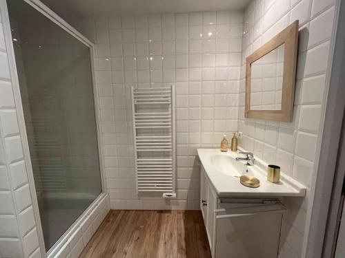 La salle de bains blanche est pourvue d'un lavabo et d'une douche. dans l'établissement Superbe appartement COURCHEVEL VILLAGE, à Courchevel