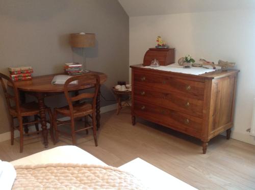 une chambre avec une commode, une table et un lit dans l'établissement La Maison du Carroir, à Blois