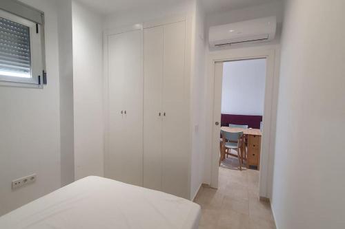 - une chambre blanche avec un lit et une table dans l'établissement Relax en primera línea AP4, à El Campello
