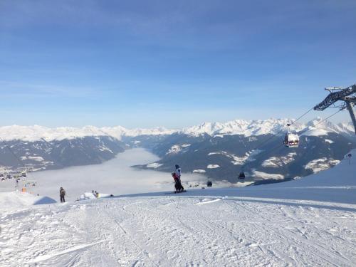 a group of people on a ski slope with a ski lift at Hotel B&B Martha in Brunico